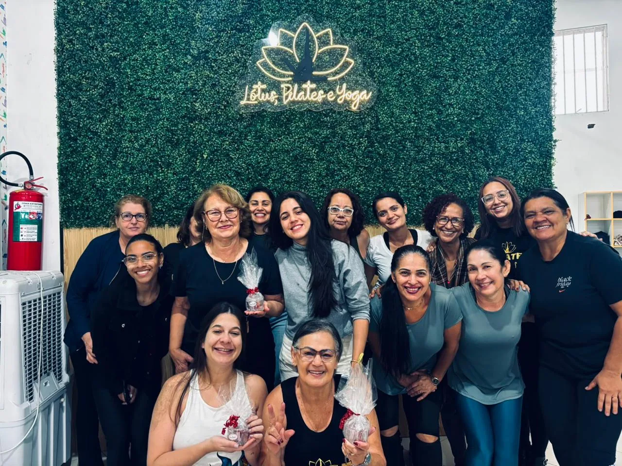 Alunas do Studio Lótus reunidas diante do painel iluminado